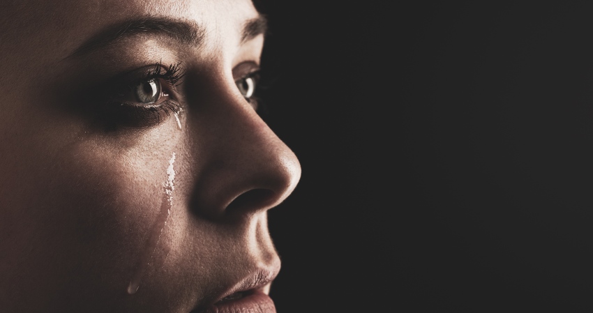 Nachaufnahme Gesicht einer jungen Frau mit Tränen auf der Wange